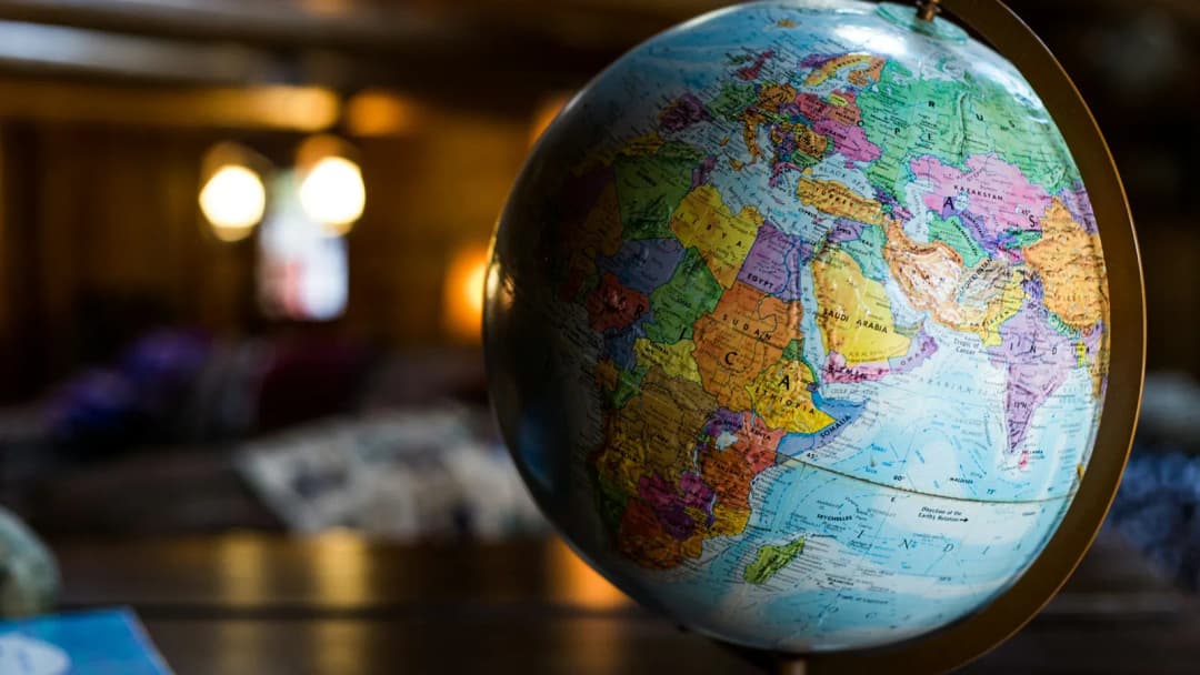 A colourful desk globe with warm bokeh lights in the background.