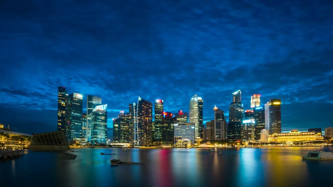 Singapore city skyline at blue hour with towers lit and reflected on dark water